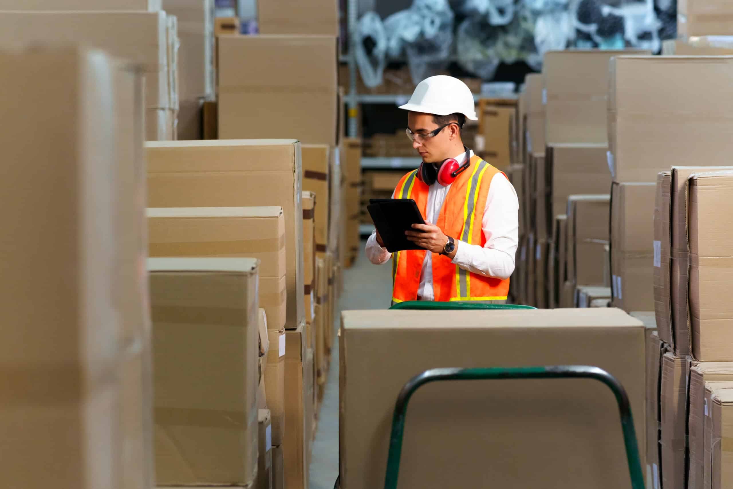 Warehouse worker checking boxed furniture stock
