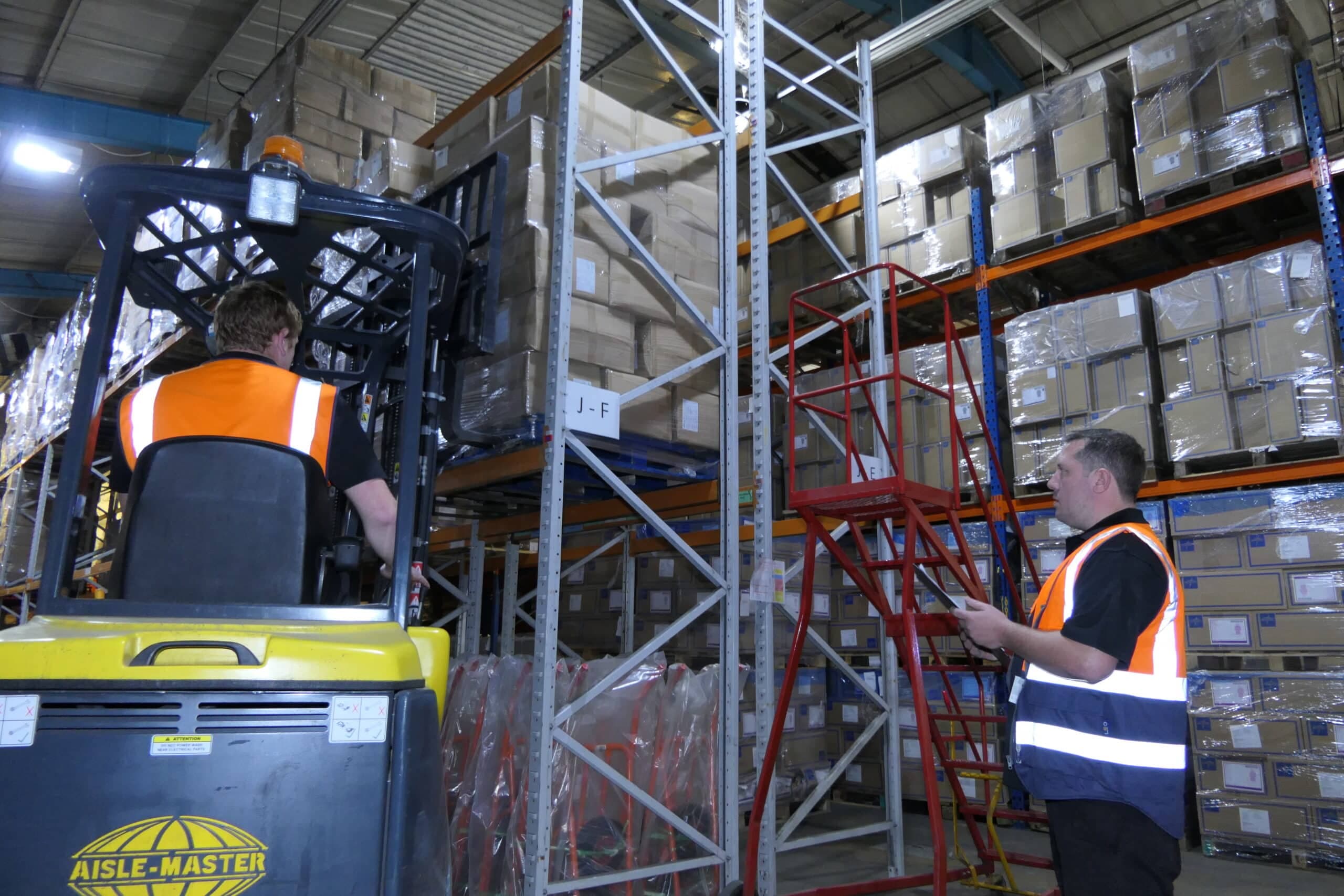 Warehouse team working around pallet racking